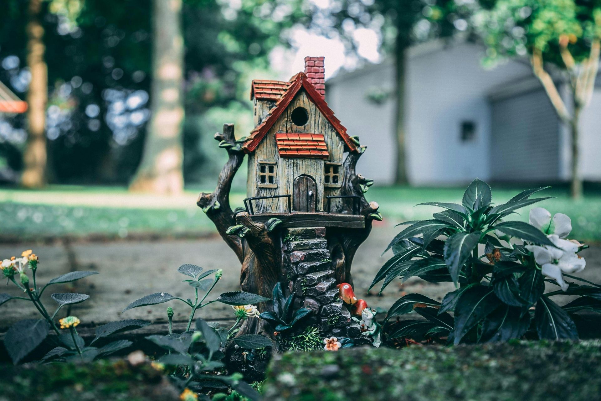 Une maison miniature pleine de fantaisie, nichée au cœur d'un jardin féerique luxuriant, évoquant un sentiment d'enchantement et de merveilleux.